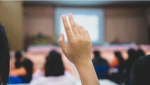 A picture of a person hand raised at a public gathering.