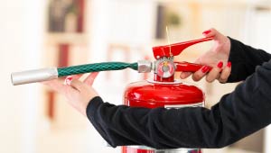 A person holding a red fire extinguisher