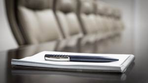A picture of a notepad and pen on a desk