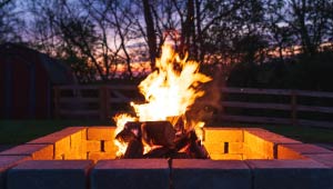 A picture of a backyard lite brick fire pit at dusk.
